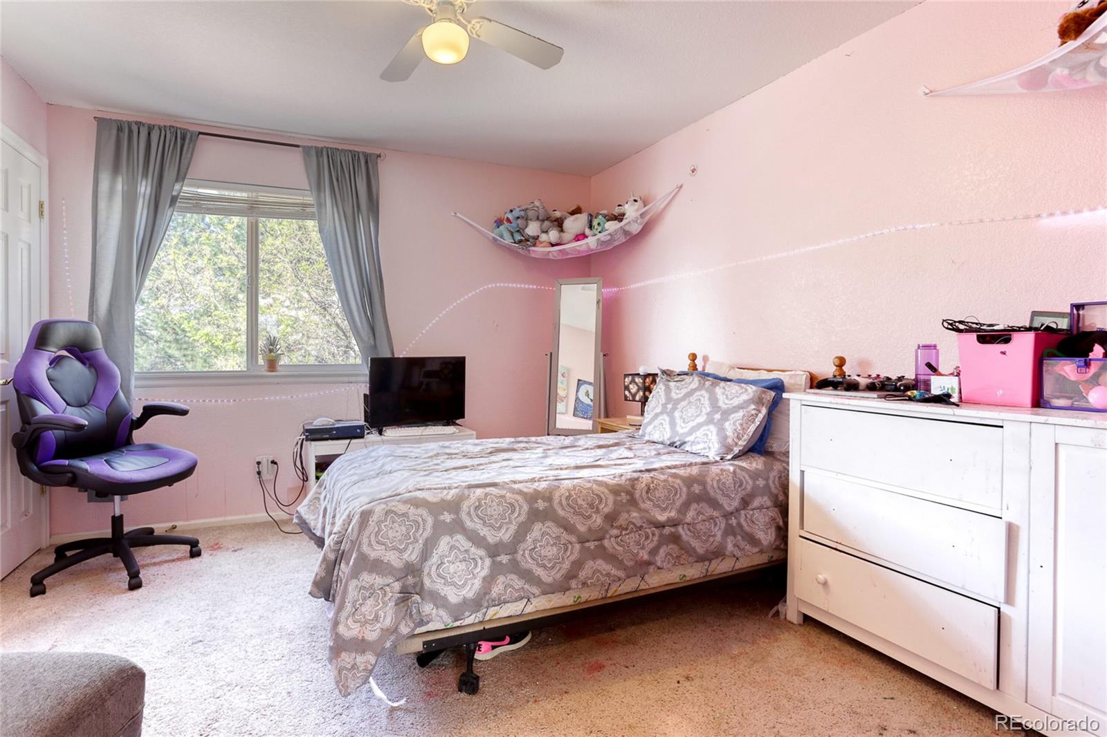 4425 Iran Street Denver, CO 80249 - Photo 17 of 36 a bedroom with a bed and a chandelier