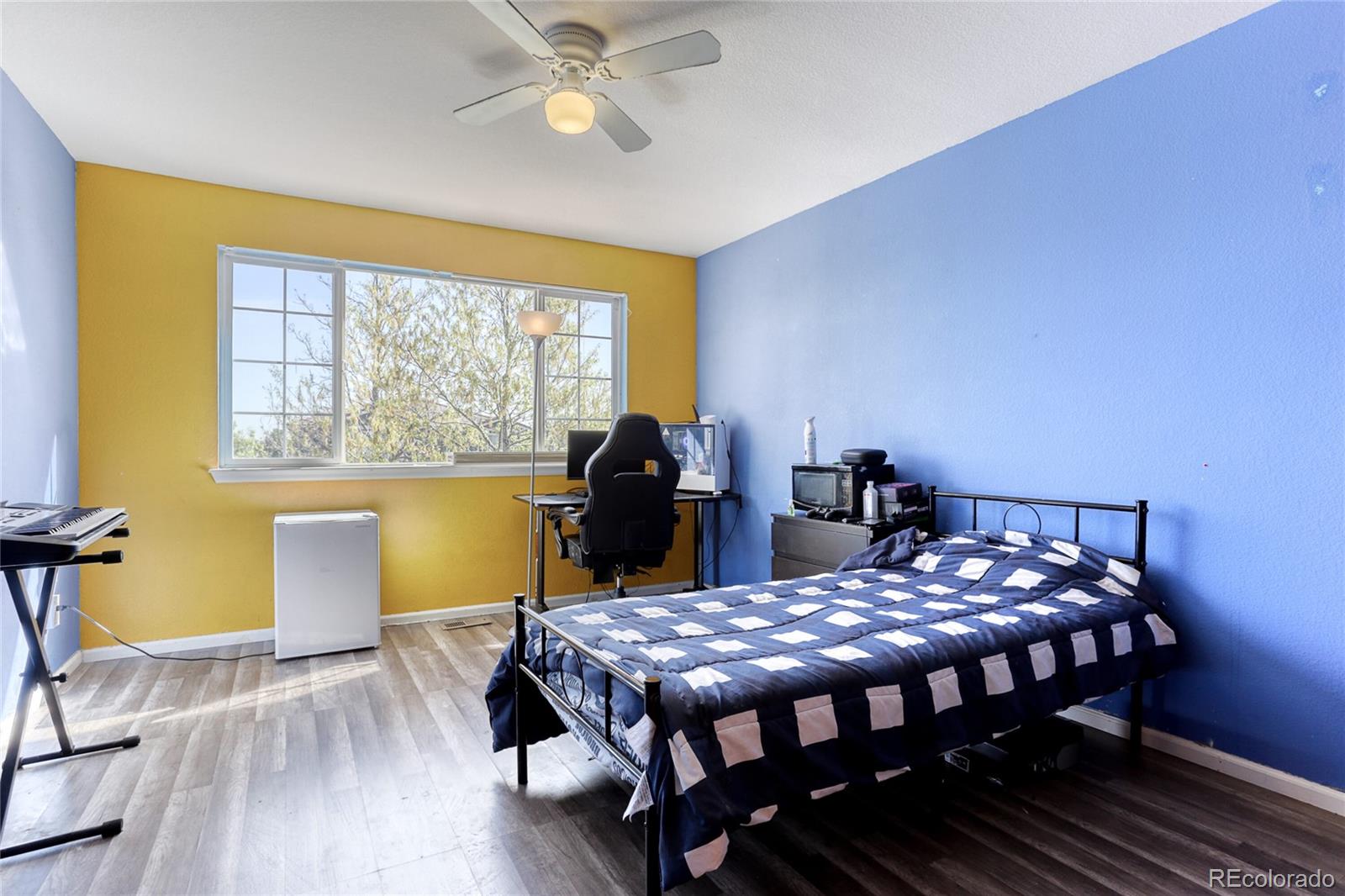 4425 Iran Street Denver, CO 80249 - Photo 18 of 36 a bedroom with a bed and wooden floor