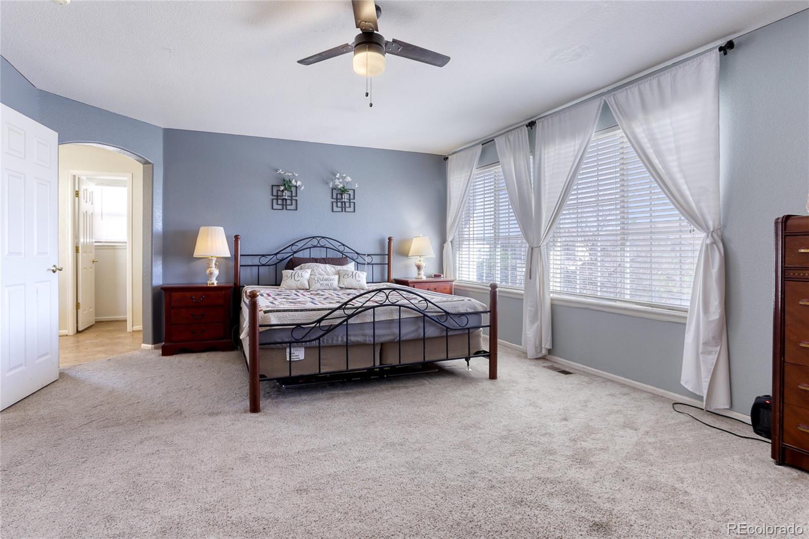 4425 Iran Street Denver, CO 80249 - Photo 21 of 36 a bedroom with a bed and a chandelier