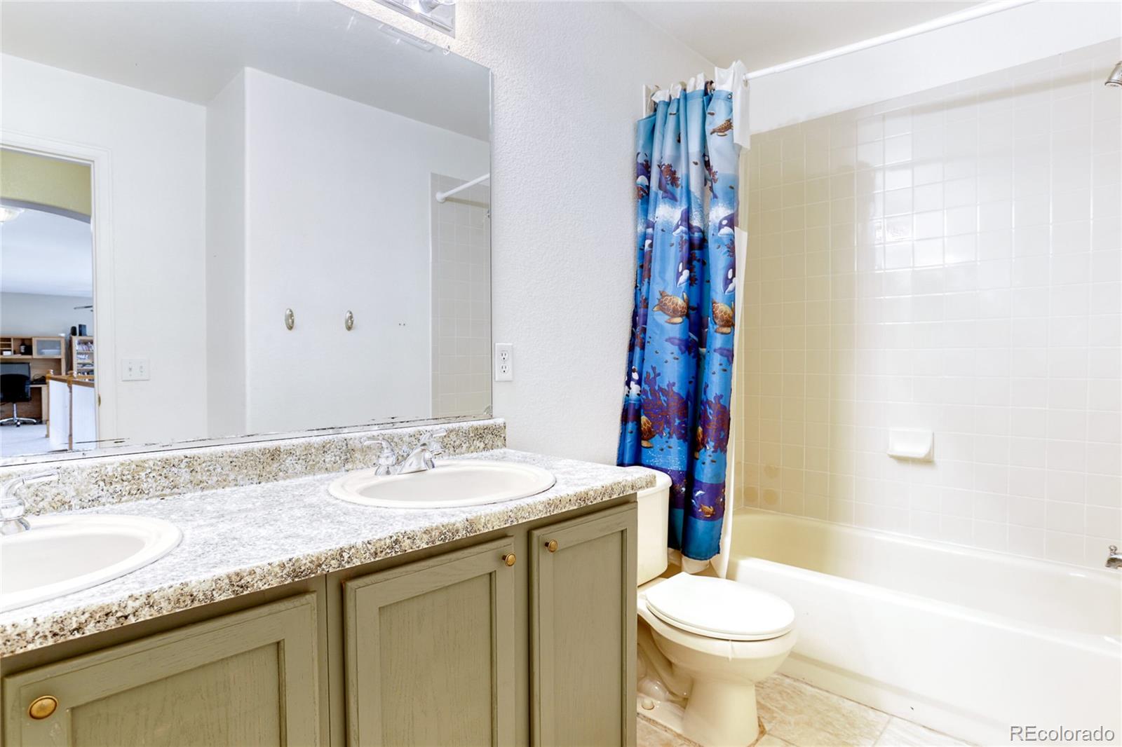 4425 Iran Street Denver, CO 80249 - Photo 26 of 36 a bathroom with a granite countertop sink toilet and shower