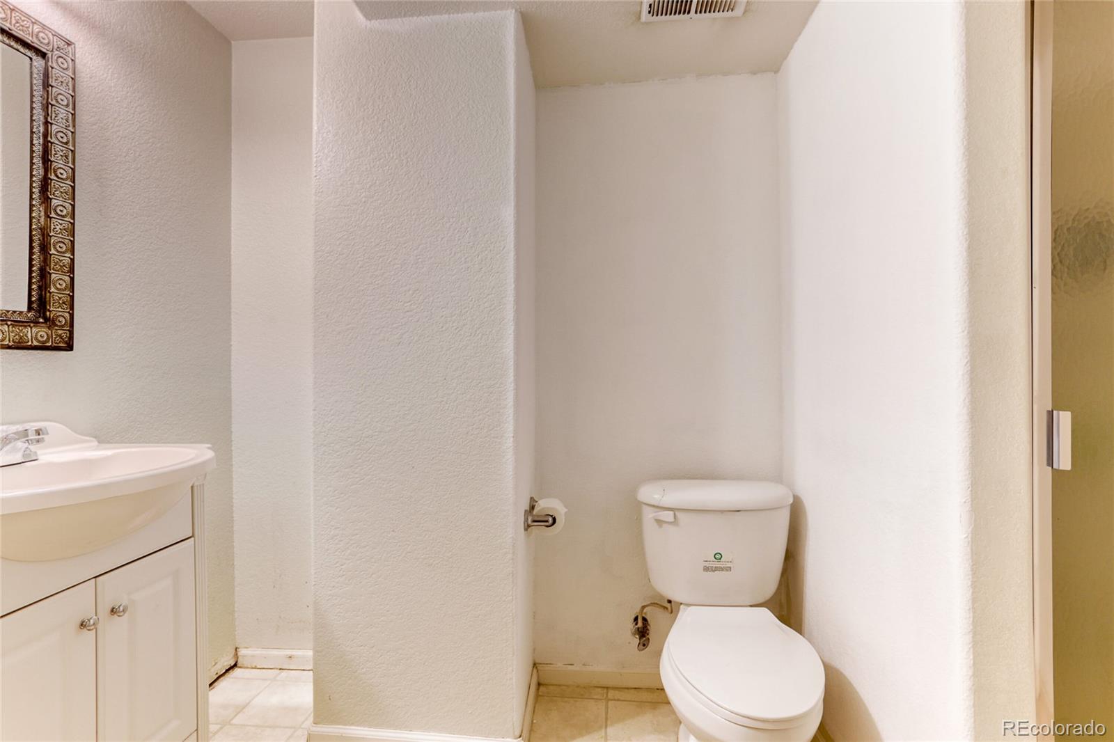 4425 Iran Street Denver, CO 80249 - Photo 27 of 36 a bathroom with a toilet a sink and a mirror