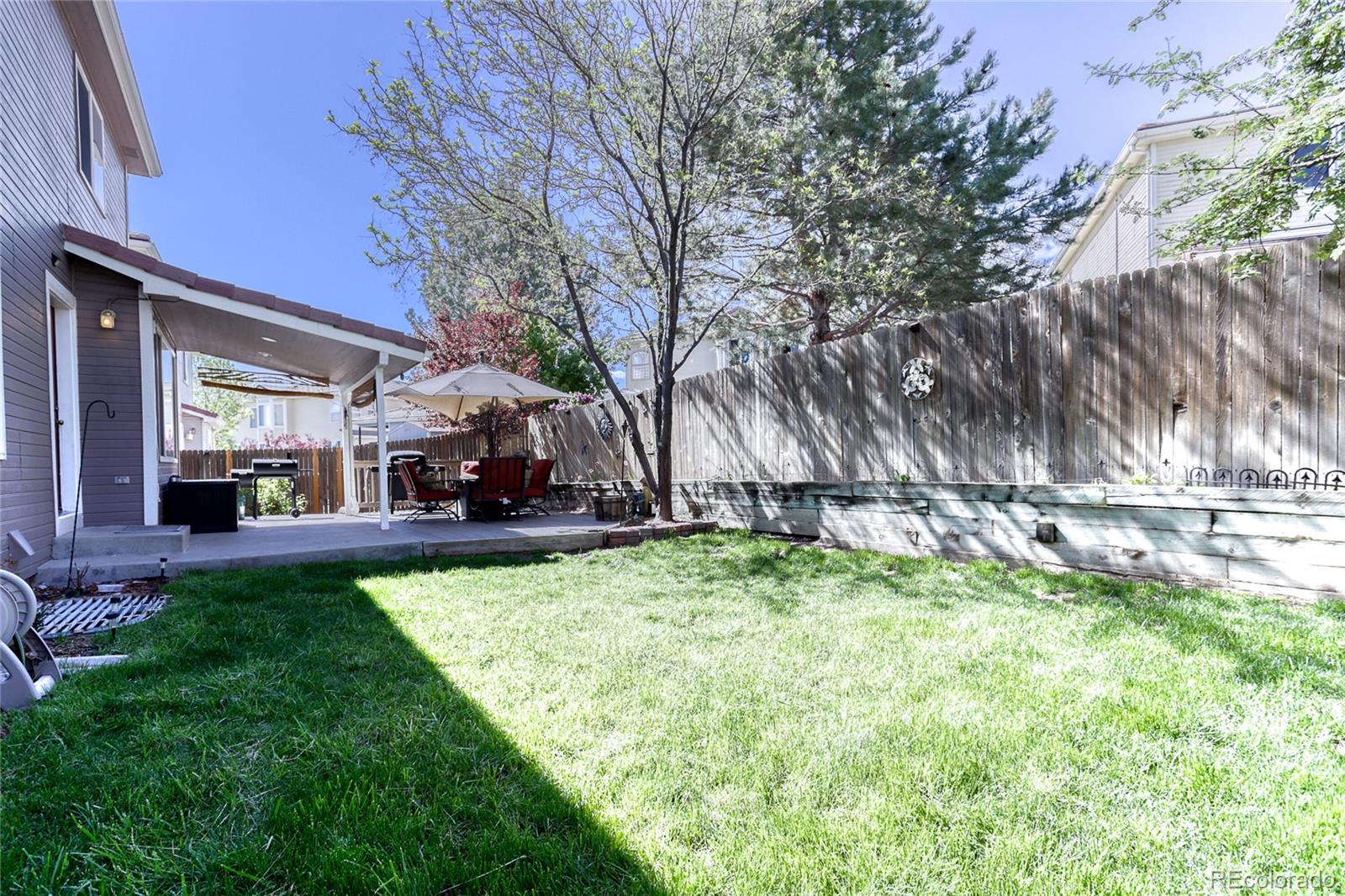 4425 Iran Street Denver, CO 80249 - Photo 31 of 36 a view of a backyard with couches plants and large trees