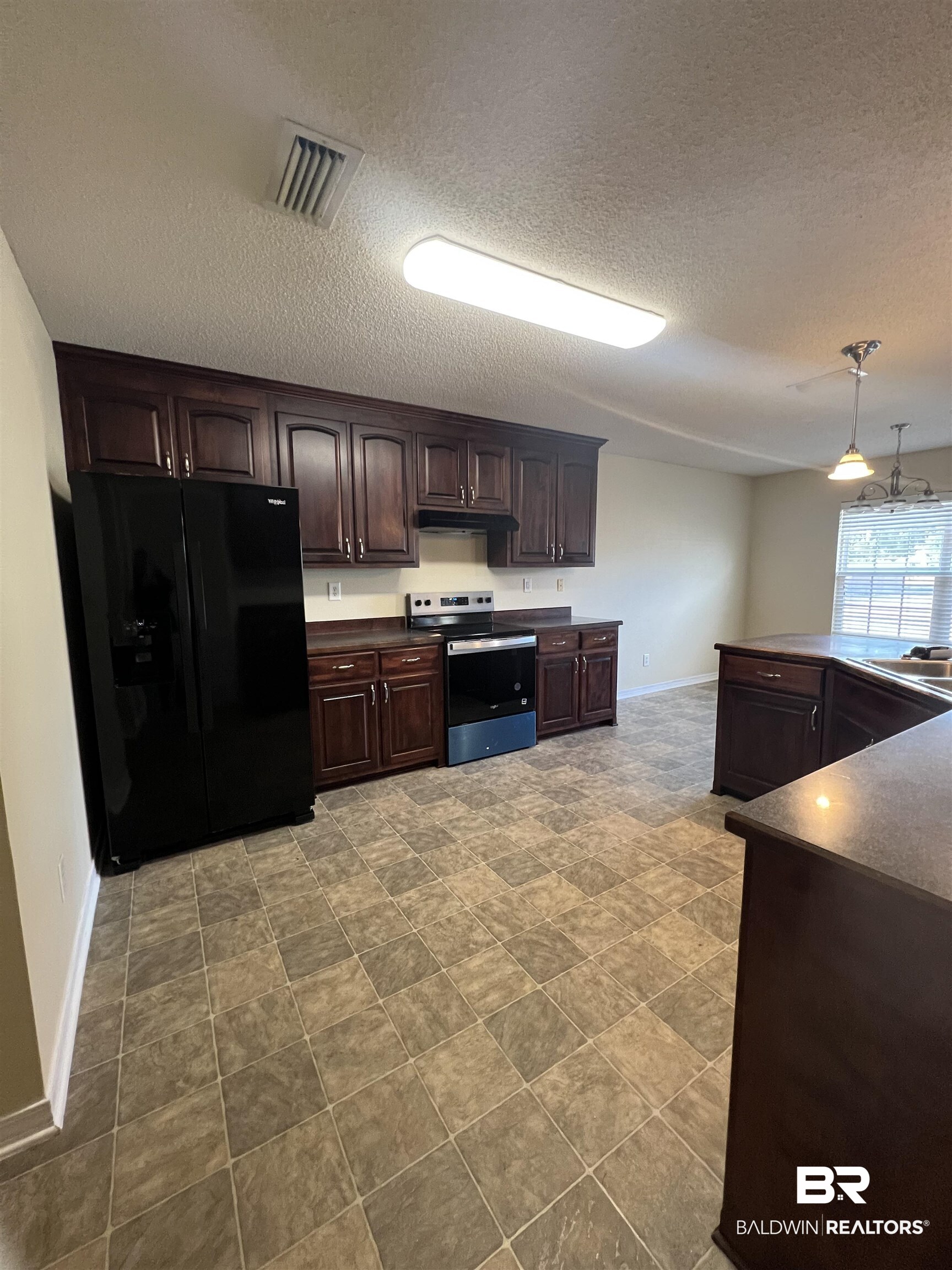 17793 Fancy Boulevard Foley, AL 36535 - Photo 8 of 34 Kitchen with stainless steel electric stove, hanging light fixtures, dark brown cabinetry, a textured ceiling, and black refrigerator with ice dispenser