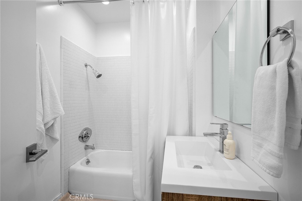 5435 Yarmouth Avenue, Unit 7 Encino, CA 91316 - Photo 19 of 31 a white bath tub sitting next to a white sink and a shower
