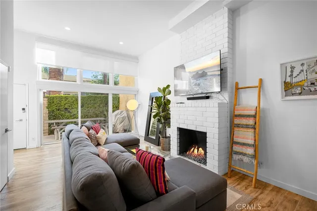 a living room with furniture a fireplace and a floor to ceiling window