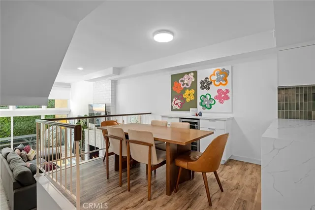 a view of a dining room with furniture one side kitchen view and wooden floor