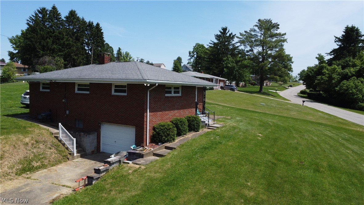 72260 Barton Road Dillonvale, OH 43917 - Photo 4 of 12 View of home's exterior featuring a garage and a yard