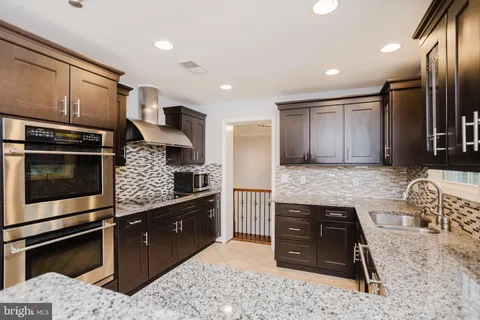 a kitchen with stainless steel appliances kitchen island granite countertop a stove a sink and a microwave