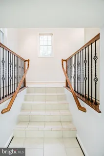 a view of staircase with white walls and a window