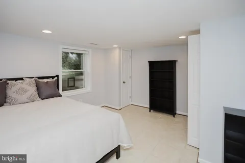 a large bedroom with a bed and a refrigerator