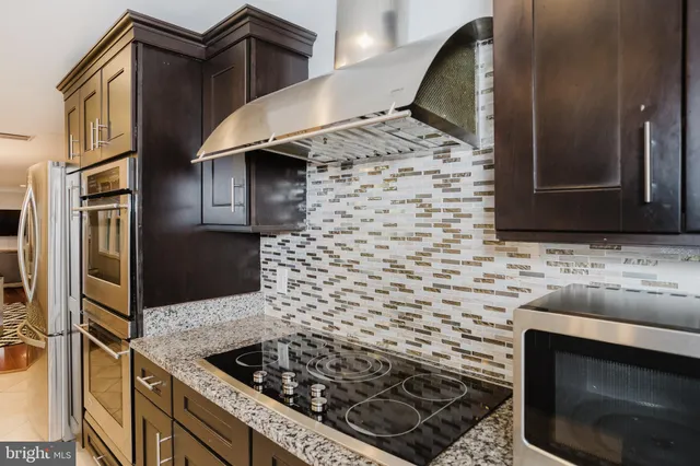 a kitchen with stainless steel appliances granite countertop a stove and a sink