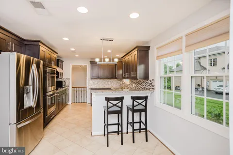 a kitchen with kitchen island a large window appliances and furniture