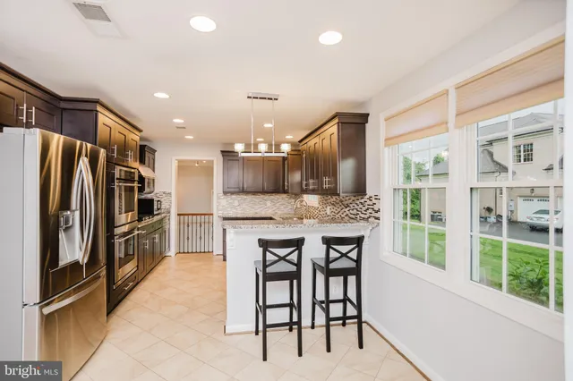 a kitchen with kitchen island a large window appliances and furniture