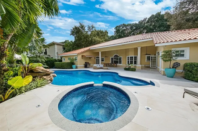 a view of a house with swimming pool and sitting area