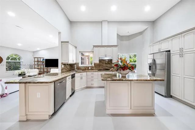 a kitchen with stainless steel appliances kitchen island granite countertop a sink and cabinets