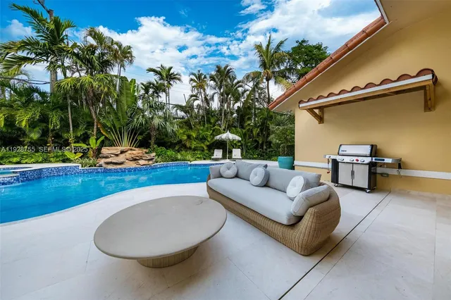 a view of a house with pool fire pit and sitting area