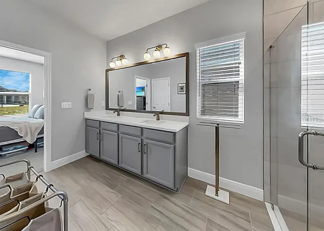 a spacious bathroom with a double vanity sink a mirror and a window