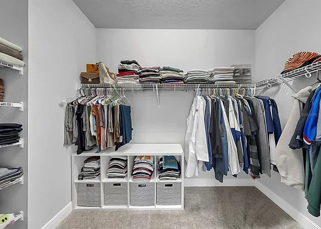 a view of walk in closet with clothes and shoes