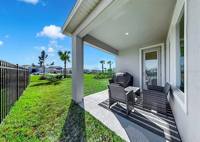 a view of a patio with chair and tables back yard of the house
