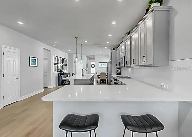 a kitchen with stainless steel appliances kitchen island a table and chairs in it