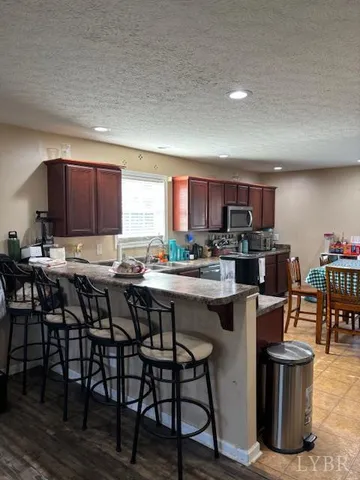 a kitchen with stainless steel appliances granite countertop table chairs sink and cabinets