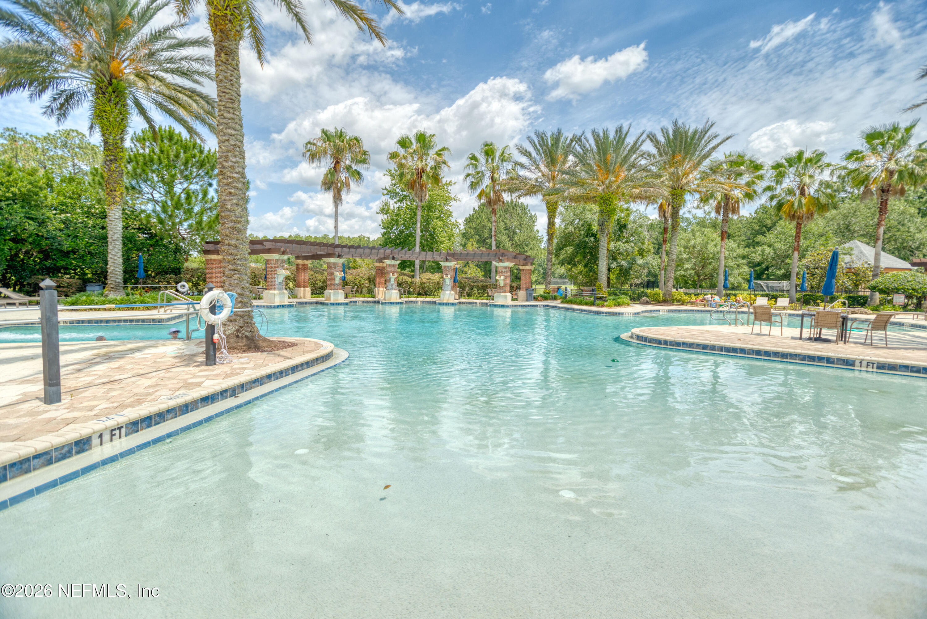 191 South Arabella Way St. Johns, FL 32259 - Photo 52 of 57 a view of a swimming pool with a lawn chairs under palm trees