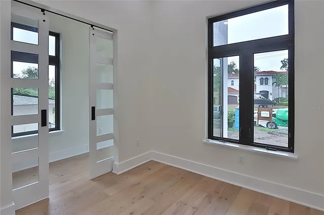 a view of a hallway with wooden floor and staircase