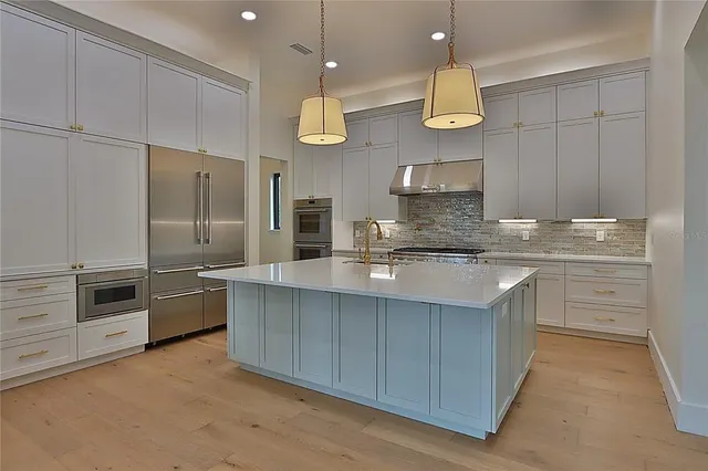 a kitchen with stainless steel appliances a sink a stove and a wooden floors
