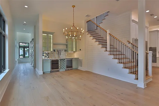 a view of a big room with wooden floor and windows