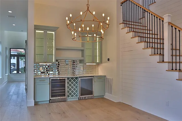 a view of a hallway with wooden floor and a bathroom