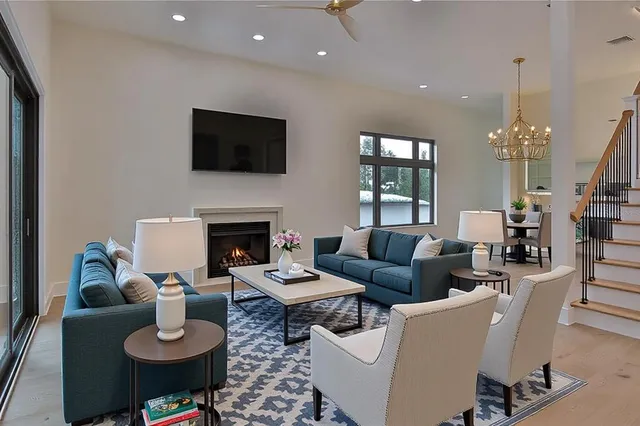 a living room with furniture kitchen view and a chandelier