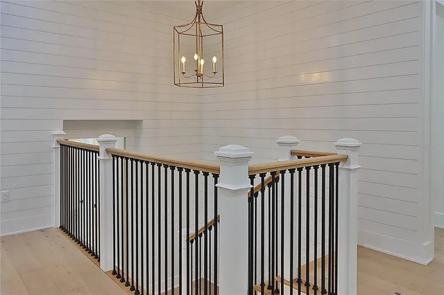 a view of a white house with a small yard plants and a large tree