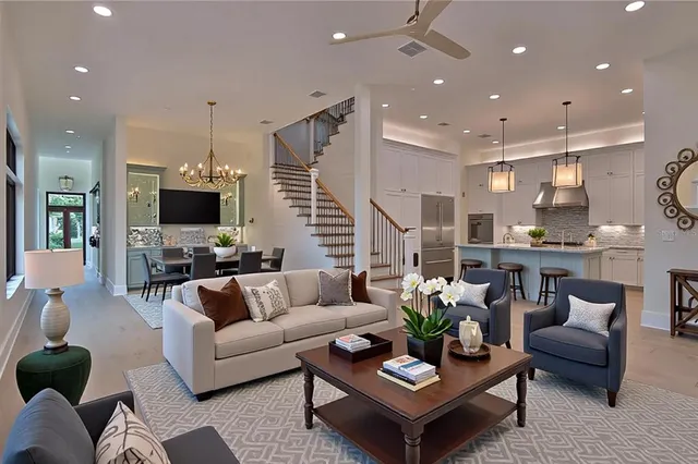 a living room with furniture kitchen view and a chandelier