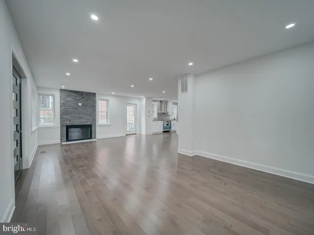 a large white kitchen with kitchen island white cabinets and stainless steel appliances