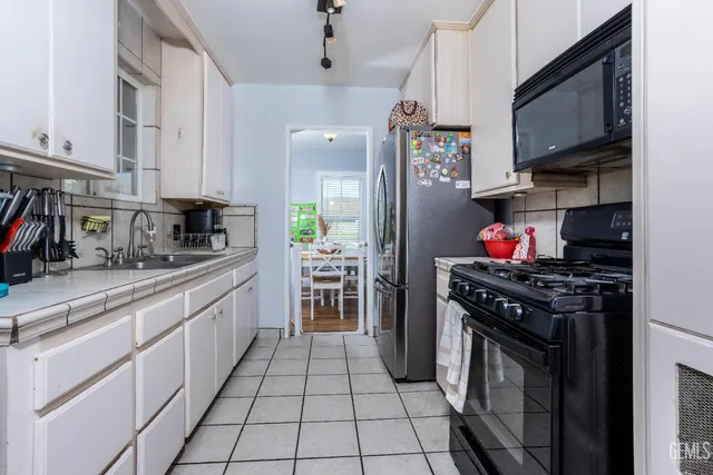 a kitchen with stainless steel appliances granite countertop a stove top oven a sink a counter space and cabinets