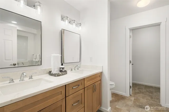a bathroom with double sink and a mirror
