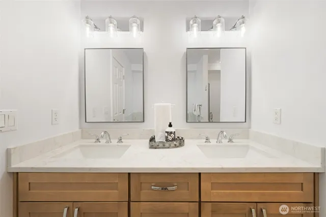 a bathroom with double vanity sinks and a mirror