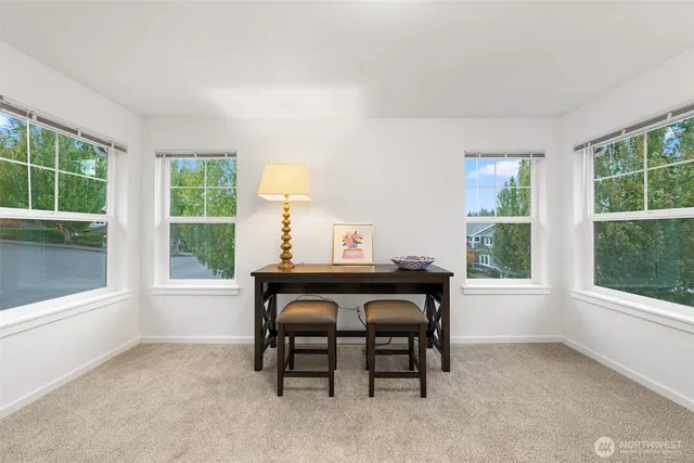 a view of a workspace with furniture and a window