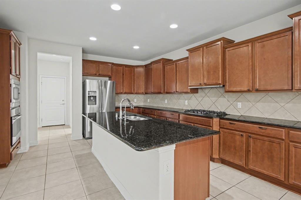6131 Myrtle Lane Frisco, TX 75036 - Photo 12 of 34 a kitchen with stainless steel appliances granite countertop a refrigerator sink and cabinets