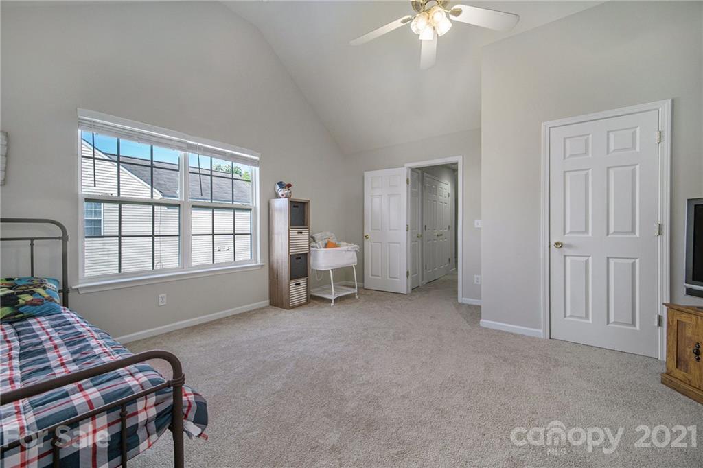 2778 Rustic Ridge Court Rock Hill, SC 29730 - Photo 29 of 34 a spacious bedroom with a bed and a chandelier