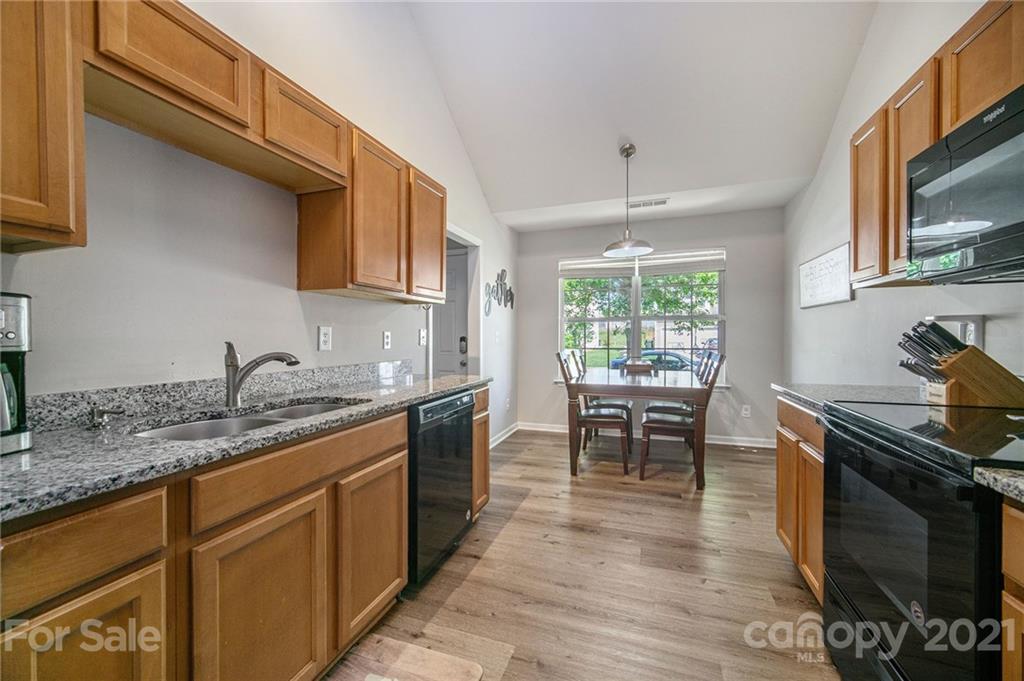 2778 Rustic Ridge Court Rock Hill, SC 29730 - Photo 7 of 34 a kitchen with granite countertop a stove a sink a dining table and chairs