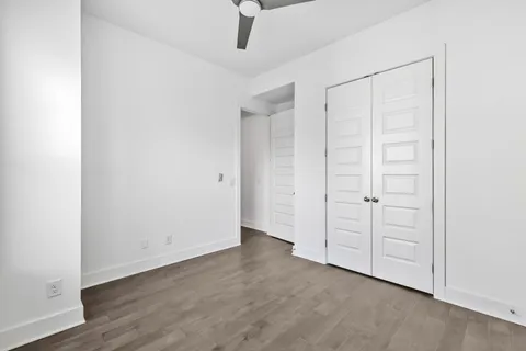 an empty room with a hardwood and ceiling fan