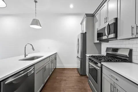 a kitchen with stainless steel appliances granite countertop a sink a stove and a refrigerator