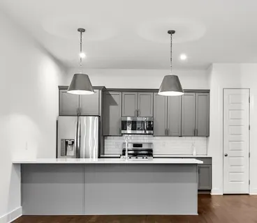 a kitchen with stainless steel appliances granite countertop a sink a stove and a refrigerator