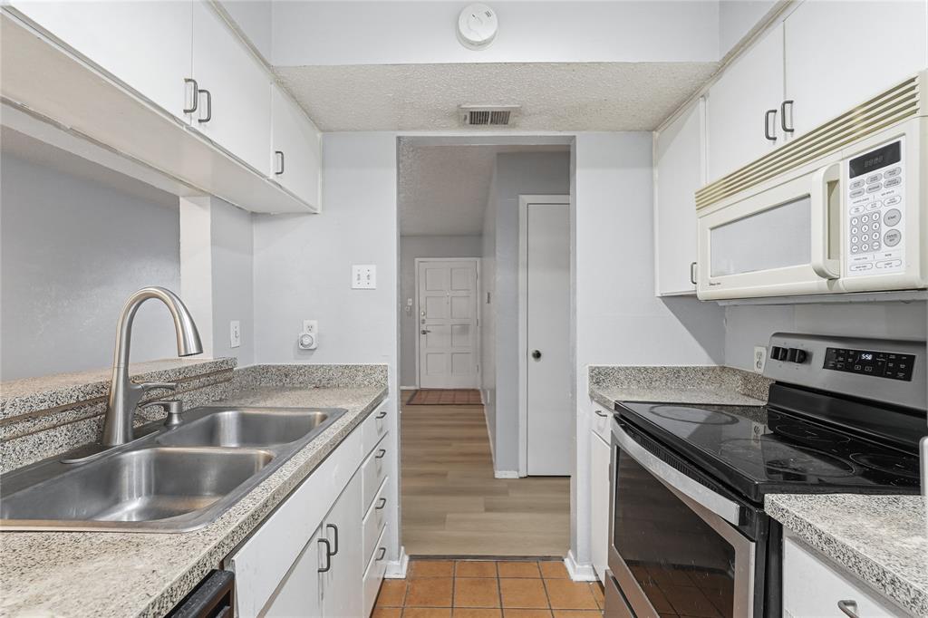 4211 Holland Avenue, Unit 105 Dallas, TX 75219 - Photo 14 of 26 a kitchen with granite countertop a sink stainless steel appliances and cabinets