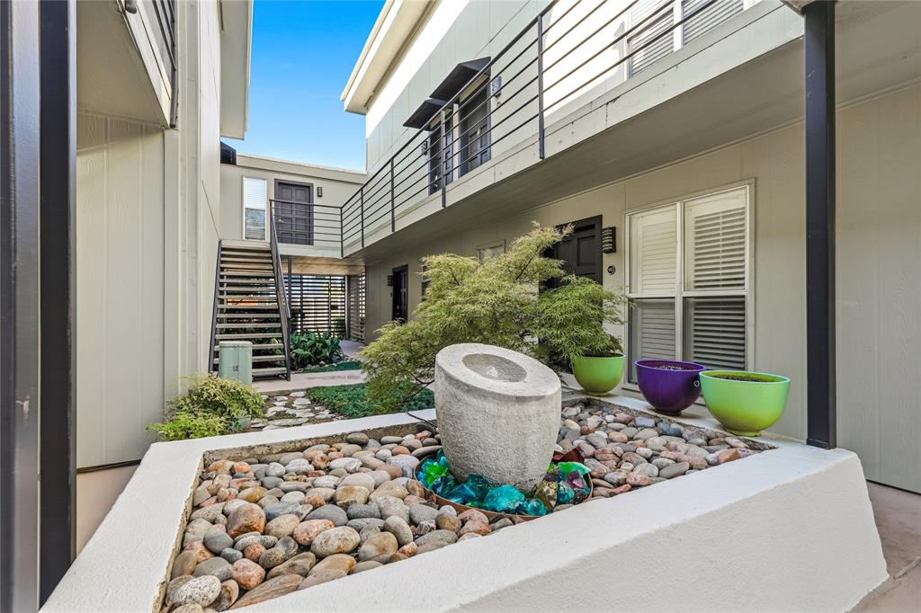 4211 Holland Avenue, Unit 105 Dallas, TX 75219 - Photo 24 of 26 a front view of a house with a fountain and potted plant
