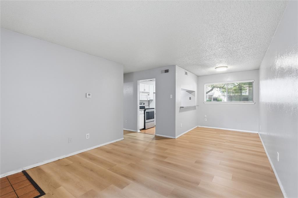 4211 Holland Avenue, Unit 105 Dallas, TX 75219 - Photo 8 of 26 a view of empty room with wooden floor and window