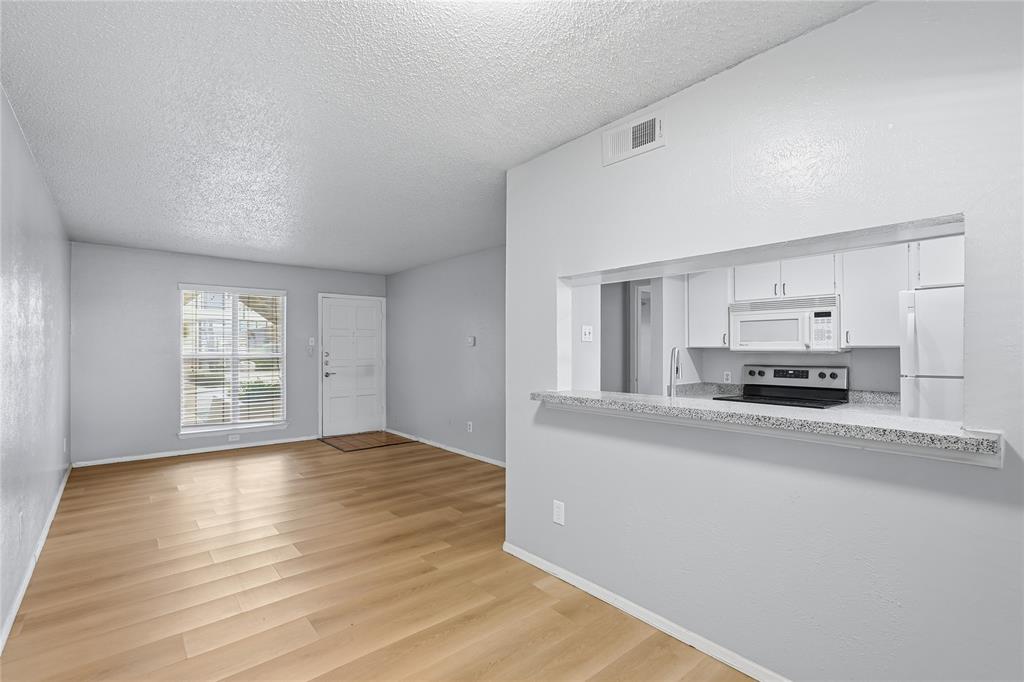 4211 Holland Avenue, Unit 105 Dallas, TX 75219 - Photo 9 of 26 a view of a kitchen cabinets and a wooden floor