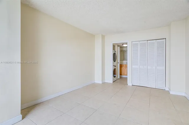 a view of an empty room with closet and entryway