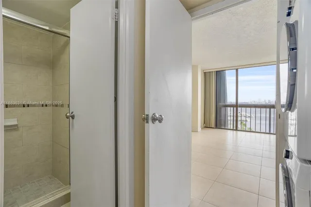 a view of a hallway with a glass door and bathroom